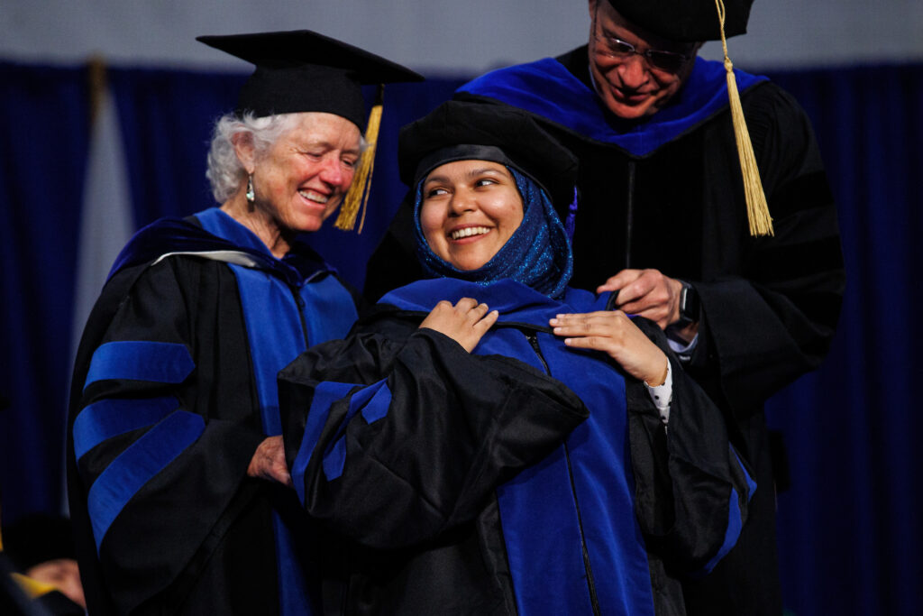 Graduate School of Biomedical Science graduates smile on the Commencement stage.