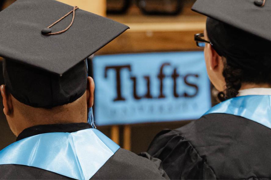 Two Tisch College Commencement attendees view the stage.